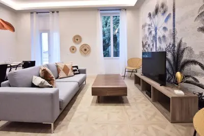 a living room with a couch and a tv at Résidence 4p Moderne En Centre-ville, 5min Palais & Plages ! - 4P moderne en centre-ville, 5min Palais & plages ! MAE-1683 in Cannes