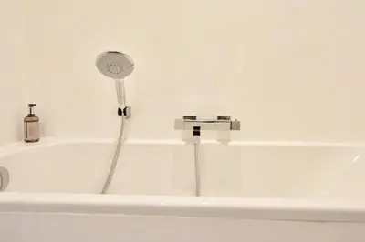 a white bath tub with a shower and a faucet at Résidence 4p Moderne En Centre-ville, 5min Palais & Plages ! - 4P moderne en centre-ville, 5min Palais & plages ! MAE-1683 in Cannes