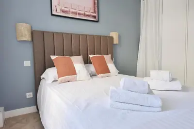a large white bed with towels on top of it at Résidence 4p Moderne En Centre-ville, 5min Palais & Plages ! - 4P moderne en centre-ville, 5min Palais & plages ! MAE-1683 in Cannes