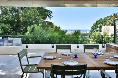 a wooden table and chairs on a patio at Résidence 4p Avec Grande Terrasse Et Piscine - 4P avec grande terrasse et piscine MAE-1693 in Cannes
