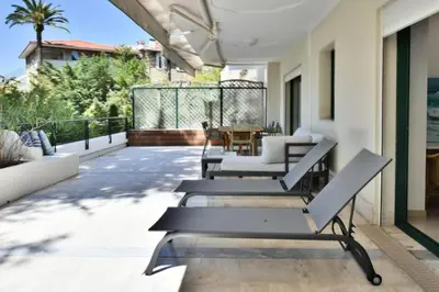 a patio with chairs and a table on a house at Résidence 4p Avec Grande Terrasse Et Piscine - 4P avec grande terrasse et piscine MAE-1693 in Cannes