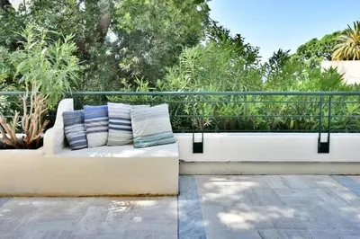 a white bench with two pillows on a balcony at Résidence 4p Avec Grande Terrasse Et Piscine - 4P avec grande terrasse et piscine MAE-1693 in Cannes