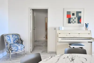 a bedroom with a piano and a chair at Résidence 4p Avec Grande Terrasse Et Piscine - 4P avec grande terrasse et piscine MAE-1693 in Cannes