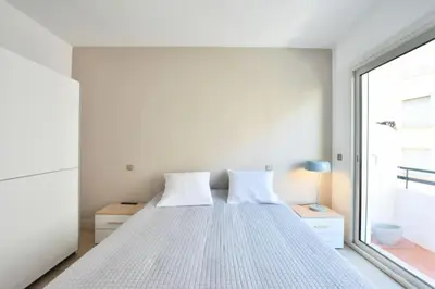 a bedroom with a bed with white sheets and a window at Résidence 3p En Plein Cœur De Cannes, à 2min De La Croisette - 3P en plein cœur de Cannes, à 2min de la Croisette MAE-1703 in Cannes