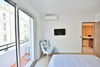 a bedroom with a bed and a chair and a window at Résidence 3p En Plein Cœur De Cannes, à 2min De La Croisette - 3P en plein cœur de Cannes, à 2min de la Croisette MAE-1703 in Cannes
