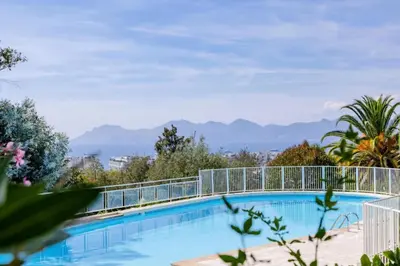 a swimming pool with mountains in the background at Résidence 2p Avec Terrasse, Vue Mer, Piscine Et Parking - 2P avec terrasse, vue mer, piscine et parking MAE-1723 in Cannes