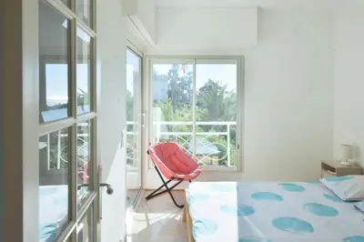 a bedroom with a red chair and a window at Résidence 2p Avec Terrasse, Vue Mer, Piscine Et Parking - 2P avec terrasse, vue mer, piscine et parking MAE-1723 in Cannes