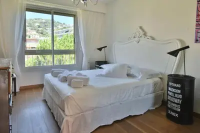a bedroom with a white bed with a large window at Résidence 2p Avec Terrasse Et Vue Mer à Deux Pas Des Plages - 2P avec Terrasse et Vue Mer à deux pas des Plages MAE-1733 in Cannes