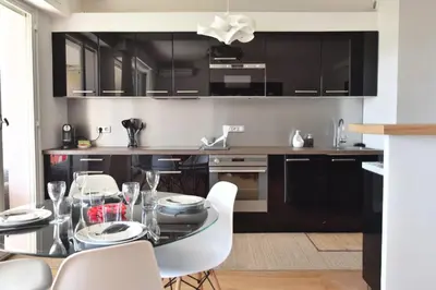 a kitchen with a glass table and white chairs at Résidence 2p Avec Terrasse Et Vue Mer à Deux Pas Des Plages - 2P avec Terrasse et Vue Mer à deux pas des Plages MAE-1733 in Cannes
