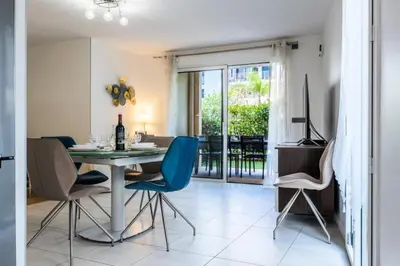 a dining room with a table and blue chairs at Résidence Rez-de-jardin Palm Beach, Piscine, Plages à Pied - Rez-de-jardin Palm Beach, piscine, plages à pied MAE-1753 in Cannes