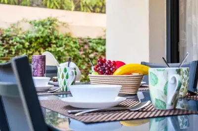 a table with bowls of fruit and plates on it at Résidence Rez-de-jardin Palm Beach, Piscine, Plages à Pied - Rez-de-jardin Palm Beach, piscine, plages à pied MAE-1753 in Cannes