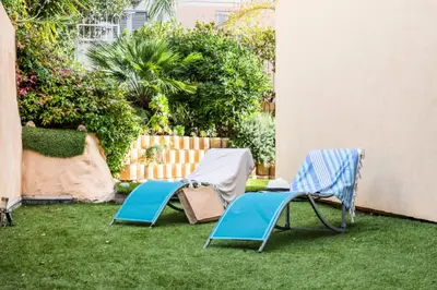 two lawn chairs sitting on the grass in a yard at Résidence Rez-de-jardin Palm Beach, Piscine, Plages à Pied - Rez-de-jardin Palm Beach, piscine, plages à pied MAE-1753 in Cannes