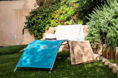a chair and a bag sitting on the grass at Résidence Rez-de-jardin Palm Beach, Piscine, Plages à Pied - Rez-de-jardin Palm Beach, piscine, plages à pied MAE-1753 in Cannes