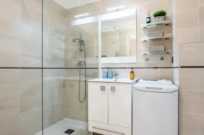 a white bathroom with a shower and a sink at Résidence Rez-de-jardin Palm Beach, Piscine, Plages à Pied - Rez-de-jardin Palm Beach, piscine, plages à pied MAE-1753 in Cannes