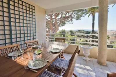 a dining room with a wooden table and chairs at Résidence 3 Pièces En Résidence Avec Piscine Et Vue Mer - 3 Pièces en Résidence avec Piscine et Vue Mer MAE-1793 in Cannes