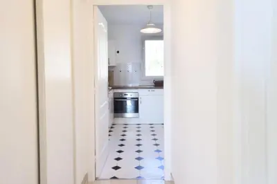 a kitchen with white appliances and a black and white floor at Résidence 3 Pièces En Résidence Avec Piscine Et Vue Mer - 3 Pièces en Résidence avec Piscine et Vue Mer MAE-1793 in Cannes