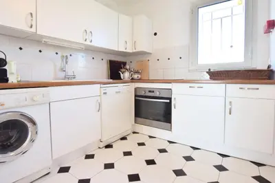 a kitchen with white cabinets and a black and white checkered floor at Résidence 3 Pièces En Résidence Avec Piscine Et Vue Mer - 3 Pièces en Résidence avec Piscine et Vue Mer MAE-1793 in Cannes