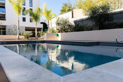 a swimming pool in front of a building at Résidence 3 Pièces Moderne Avec Piscine Au Palm Beach - 3 pièces moderne avec piscine au Palm Beach MAE-1803 in Cannes