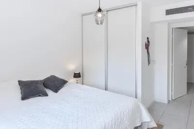 a white bedroom with a white bed with two pillows at Résidence 3 Pièces Moderne Avec Piscine Au Palm Beach - 3 pièces moderne avec piscine au Palm Beach MAE-1803 in Cannes
