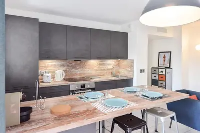 a kitchen with a table with blue plates on it at Résidence 3 Pièces Moderne Avec Piscine Au Palm Beach - 3 pièces moderne avec piscine au Palm Beach MAE-1803 in Cannes