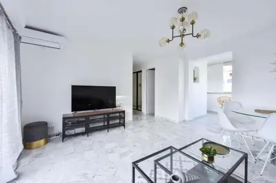 a living room with a television and a table at Résidence Cannes Palm Beach, 2 Min Des Plages - Cannes Palm beach, 2 min des plages MAE-1813 in Cannes