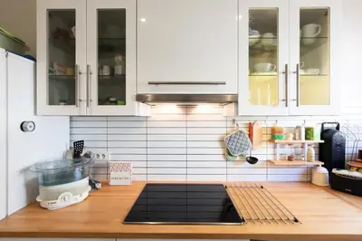 a kitchen with white cabinets and a wooden counter top at Résidence 3 Pièces En Centre-ville, Proche Croisette&palais - 3 pièces en centre-ville, proche Croisette&Palais MAE-1833 in Cannes