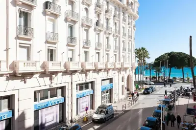 a tall white building with cars parked on a street at Résidence 3 Pièces En Centre-ville, Proche Croisette&palais - 3 pièces en centre-ville, proche Croisette&Palais MAE-1833 in Cannes