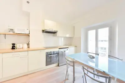 a white kitchen with a blue table and chairs at Résidence 3p Moderne En Centre Ville, à 1min De La Croisette - 3P moderne en centre ville, à 1min de la Croisette MAE-1843 in Cannes