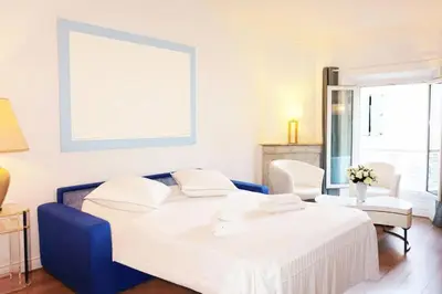 a bedroom with a white bed and two chairs at Résidence 3p Moderne En Centre Ville, à 1min De La Croisette - 3P moderne en centre ville, à 1min de la Croisette MAE-1843 in Cannes