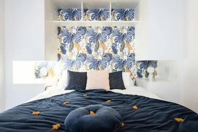 a bed with two blue pillows on top of it at Résidence 3p Moderne Avec Terrasse En Plein Coeur De Cannes - 3P moderne avec terrasse en plein coeur de Cannes MAE-1863 in Cannes