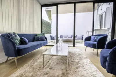 a living room with blue couches and a glass table at Résidence 3p Moderne Avec Terrasse En Plein Coeur De Cannes - 3P moderne avec terrasse en plein coeur de Cannes MAE-1863 in Cannes