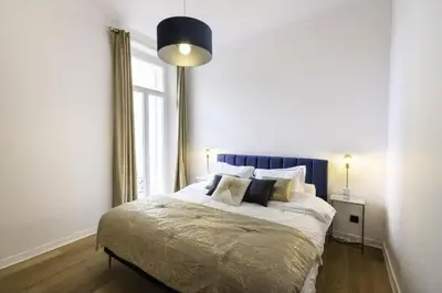 a bedroom with a bed with a blue headboard and a window at Résidence 3p Moderne Avec Terrasse En Plein Coeur De Cannes - 3P moderne avec terrasse en plein coeur de Cannes MAE-1863 in Cannes