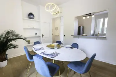 a dining room with a white table and blue chairs at Résidence 3p Moderne Avec Terrasse En Plein Coeur De Cannes - 3P moderne avec terrasse en plein coeur de Cannes MAE-1863 in Cannes