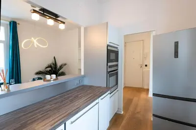 a kitchen with white cabinets and a wooden counter top at Résidence 3p Moderne Avec Terrasse En Plein Coeur De Cannes - 3P moderne avec terrasse en plein coeur de Cannes MAE-1863 in Cannes
