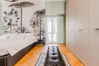 a bedroom with a bed and palm trees wallpaper at Résidence Hyper Centre Cannes - 4p à 100m Du Palais - Hyper centre Cannes - 4P à 100m du palais MAE-1873 in Cannes