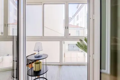 a room with large windows and a table with a lamp at Résidence Hyper Centre Cannes - 4p à 100m Du Palais - Hyper centre Cannes - 4P à 100m du palais MAE-1873 in Cannes