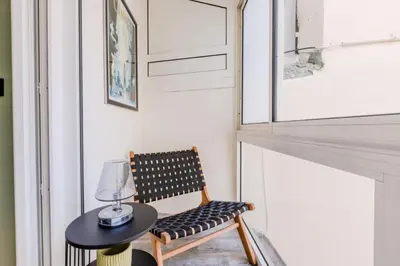 a room with a chair and a table with a lamp at Résidence Hyper Centre Cannes - 4p à 100m Du Palais - Hyper centre Cannes - 4P à 100m du palais MAE-1873 in Cannes