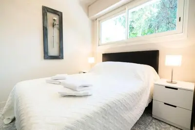 a bedroom with a white bed with a window at Résidence 3p Pointe Croisette, Au Calme, Plages à Pied - 3P pointe Croisette, au calme, plages à pied MAE-1883 in Cannes