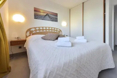 a bedroom with a white bed with towels on it at Résidence 4 Pièces Refait à Neuf, 3 Min De La Croisette - 4 pièces refait à neuf, 3 min de la Croisette MAE-1893 in Cannes