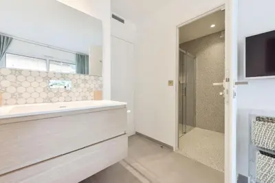a bathroom with a sink and a mirror and a television at Résidence 4 Pièces Refait à Neuf, 3 Min De La Croisette - 4 pièces refait à neuf, 3 min de la Croisette MAE-1893 in Cannes