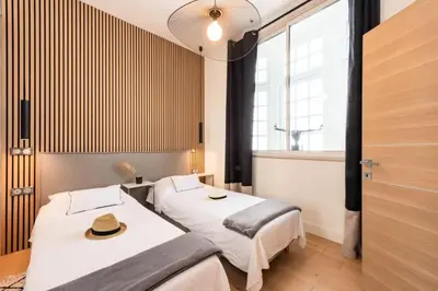 a room with two beds and a window at Résidence 3p Cosy, 1 Min Des Plages Et 3min Du Centre-ville - 3P Cosy, 1 min des plages et 3min du centre-ville MAE-1903 in Cannes