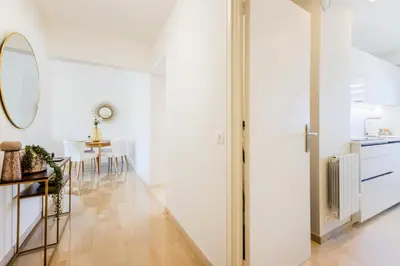 a white hallway with a table and a mirror at Résidence 2p De Style Avec Terrasse, Plages Et Commerces à Pied - 2P de style avec terrasse, plages et commerces à pied MAE-1913 in Cannes
