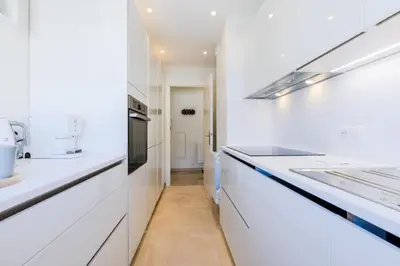 a white kitchen with white counters and appliances at Résidence 2p De Style Avec Terrasse, Plages Et Commerces à Pied - 2P de style avec terrasse, plages et commerces à pied MAE-1913 in Cannes