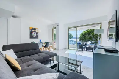 a living room with a couch and a table at Résidence 90m2 Sur La Croisette Avec Terrasse & Vue Mer - 90m2 sur la Croisette avec terrasse & vue mer MAE-1963 in Cannes