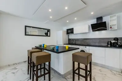 a kitchen with a counter and stools in it at Résidence 90m2 Sur La Croisette Avec Terrasse & Vue Mer - 90m2 sur la Croisette avec terrasse & vue mer MAE-1963 in Cannes