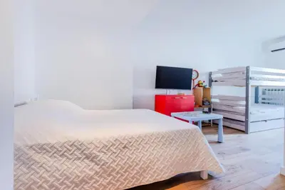 a bedroom with a white bed and a tv at Résidence 90m2 Sur La Croisette Avec Terrasse & Vue Mer - 90m2 sur la Croisette avec terrasse & vue mer MAE-1963 in Cannes