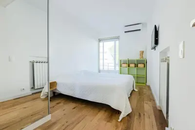 a white bedroom with a bed and a glass wall at Résidence 90m2 Sur La Croisette Avec Terrasse & Vue Mer - 90m2 sur la Croisette avec terrasse & vue mer MAE-1963 in Cannes