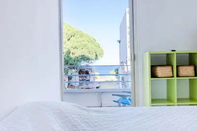 a bedroom with a bed and a view of the ocean at Résidence 90m2 Sur La Croisette Avec Terrasse & Vue Mer - 90m2 sur la Croisette avec terrasse & vue mer MAE-1963 in Cannes