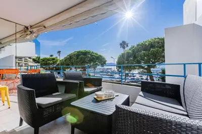 a balcony with chairs and a table on a ship at Résidence 90m2 Sur La Croisette Avec Terrasse & Vue Mer - 90m2 sur la Croisette avec terrasse & vue mer MAE-1963 in Cannes