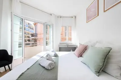 a white bed in a room with a window at Résidence 4p Carré D’or - Hyper Centre à Pied Des Plages - 4P Carré d’or - Hyper centre à pied des plages MAE-1973 in Cannes